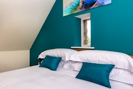 Orchard House bedroom 6 with turquoise wall, small window and a painting comfy beds in holiday accommodation  - www.bhhl.co.uk