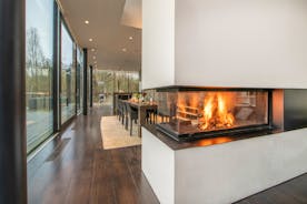 The Glass House - A glass walled wood-burner separates the dining and living areas