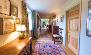 House On The Hill - A corridor packed with books and art leads to the sitting room and drawing room
