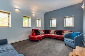  A very modern lounge with large red sofa and lots of windows at Orchard House Family and Friends accommodation Monmouthsire  - www.bhhl.co.uk