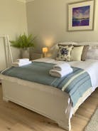 A beautiful bedroom with king size bed and views across the garden to the beach