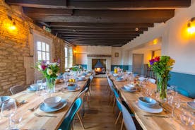 The Plough - The dining room: exposed stone walls, big chunky beams, and a wood-burner to one end