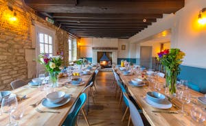 The Plough - The dining room: exposed stone walls, big chunky beams, and a wood-burner to one end