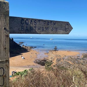 Scenic image of wooden "Coast Path Bantham" sign along the coasts of Devon