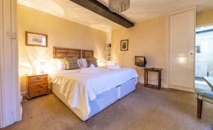 A large double bedroom with ensuite and feature black beam at Forest House, an 11 bed whole house holiday let - www.bhhl.co.uk