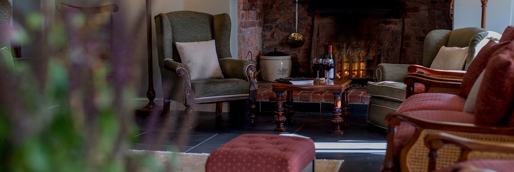 Drawing room, armchairs and drinks by the woorburning stove 