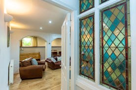 View of the basement lounge with feature stain glass windows in  Fairlea Grange large 9 bedroom holiday accommodation Monmouthshire Wales www.bhhl.co.uk