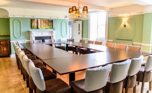 An elegant pale green dining room with tables set in a square for 20 seats - Forest House, Coleford - www.bhhl.co.uk