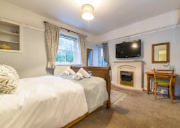A ground floor double bedroom  room 10 with large window and glass door to the garden. Gas fire and large TV at Forest House holiday let - www.bhhl.co.uk