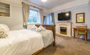 A ground floor double bedroom with large window and glass door to the garden. Gas fire and large TV at Forest House holiday let - www.bhhl.co.uk