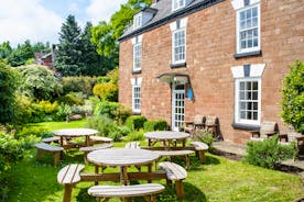 The front of Forest House showcasing the  pretty garden with picnic tables and chairs - www.bhhl.co.uk
