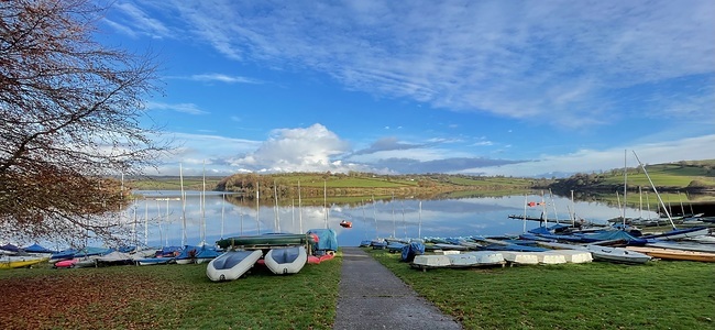 View acrooss the lake with water reflecting the sky and boats on the shore