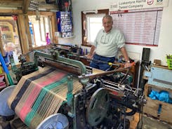 Donald J Mackay weaves Harris Tweed at Luskentyre with loom connected to Hamarsay House.