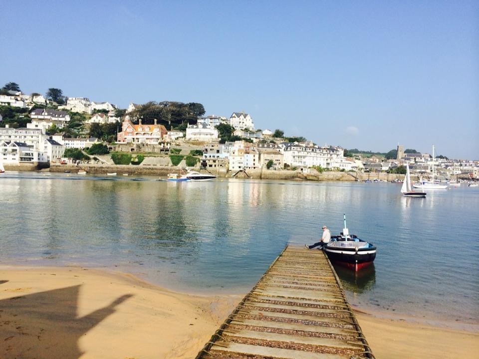 Stunning view of East Portlemouth Beach's long sandy shore, clear sea and multiple houses, ferries and other types of boats
