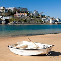 A rowboat resting on a flat land of sand belonging to the Smalls and Mill Bay