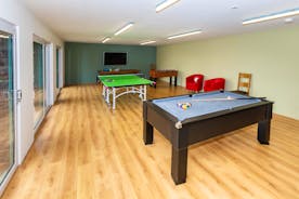 Orchard House Games Room with pool table, table tennis, table football, a TV and red leather chairs.  - www.bhhl.co.uk