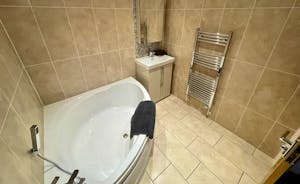 Bathroom with corner bath and heated towel rail