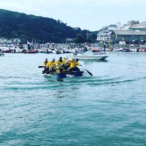 A group taking part in an exciting rowing water sports activity in somewhere around Devon