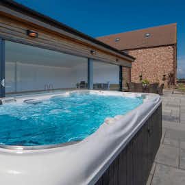 The Granary - The hot tub is on the patio just outside the pool room The Granary - The hot tub is on the patio just outside the pool room