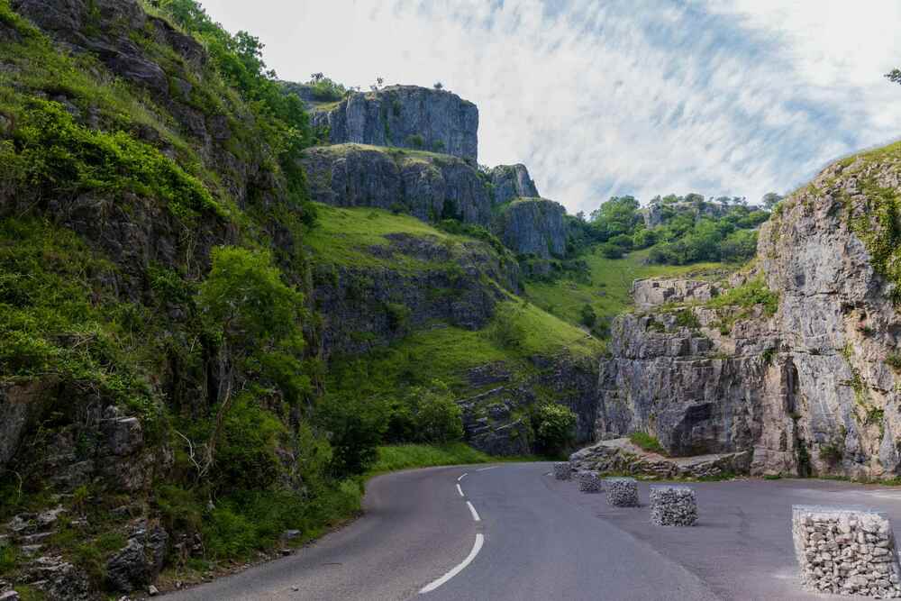 Road carving htrough dramatic cliffs topped with green