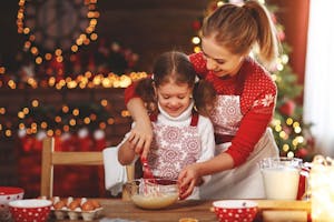 A mother helping a child mix batter at Christmas