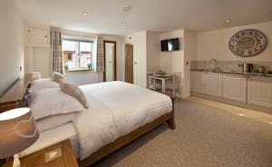 Quantock Barns - The Wagon Wheel: a ground floor suite with a super king bed, an ensuite shower room and a kitchen area